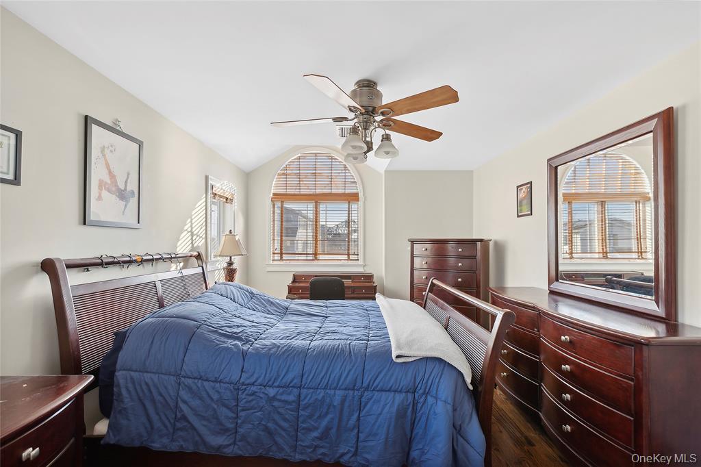 4 Quebec Road Island Park, NY 11558 - Photo 9 of 24 a bedroom with a bed and a chandelier