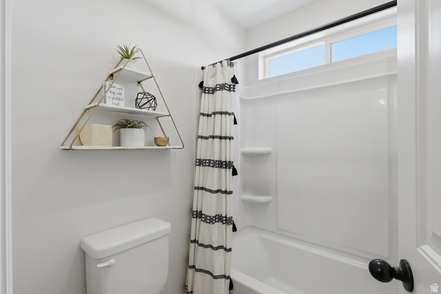 10676 Urban Rdg Cove South Jordan, UT 84095 - Photo 34 of 48 White tub and shower combination with integrated shelving, topped by an upper transom window