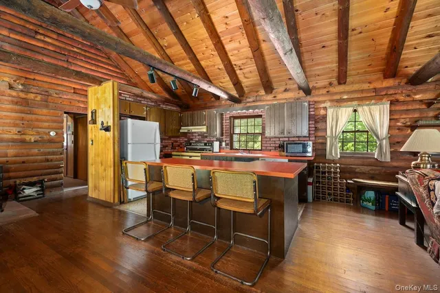 a room with lots of wooden furniture and stainless steel appliances