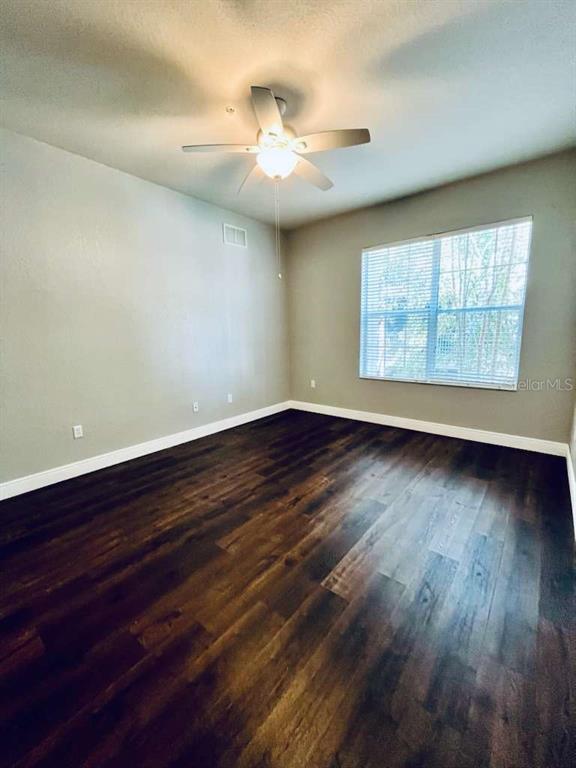 3311 Whitestone Circle, Unit 206 Kissimmee, FL 34741 - Photo 14 of 26 an empty room with wooden floor and windows