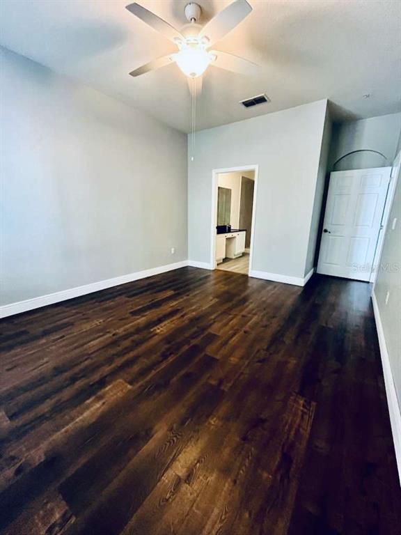 3311 Whitestone Circle, Unit 206 Kissimmee, FL 34741 - Photo 16 of 26 a view of an empty room with wooden floor and a ceiling fan
