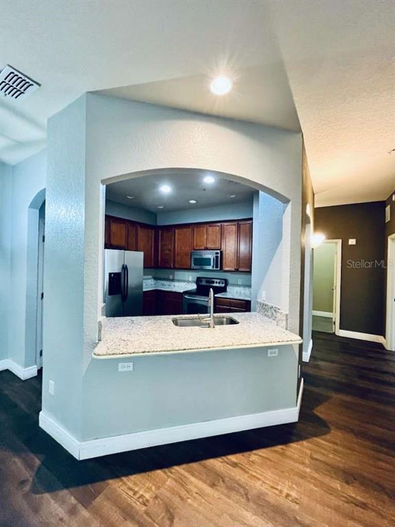 3311 Whitestone Circle, Unit 206 Kissimmee, FL 34741 - Photo 4 of 26 a large room with kitchen countertops and wooden floor