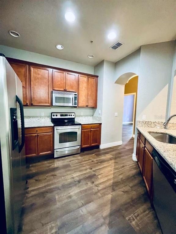 3311 Whitestone Circle, Unit 206 Kissimmee, FL 34741 - Photo 5 of 26 a kitchen with stainless steel appliances a stove sink and microwave