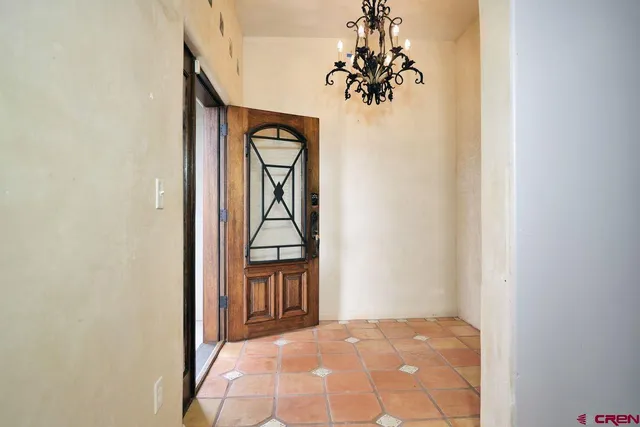 a view of a big room with windows and chandelier