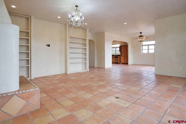 a view of an empty room with a fireplace and a window