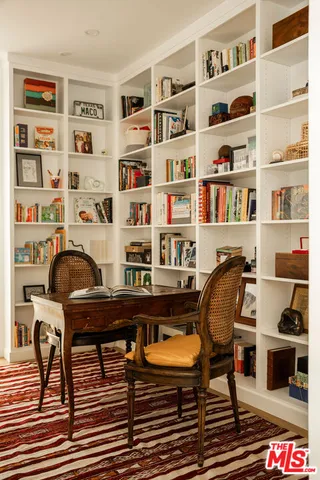a view of a workspace with furniture and bookshelf