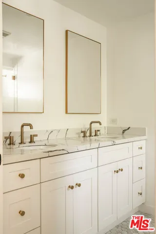 a bathroom with double sink and a mirror