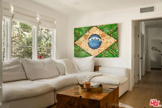 a living room with a couch and a painting on the wall