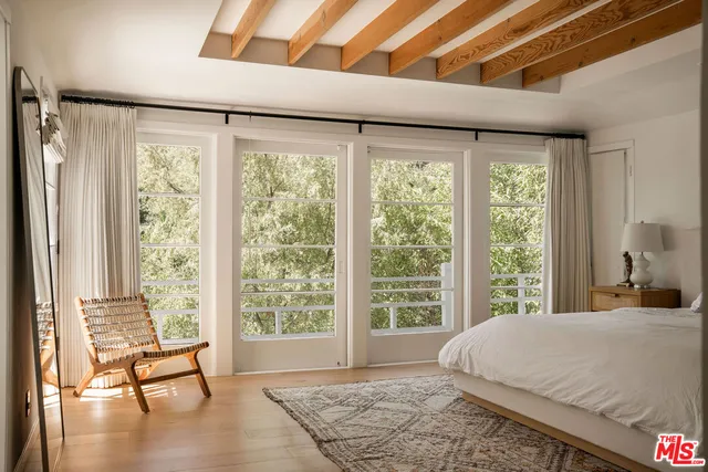 a bed sitting in a spacious bedroom next to a window