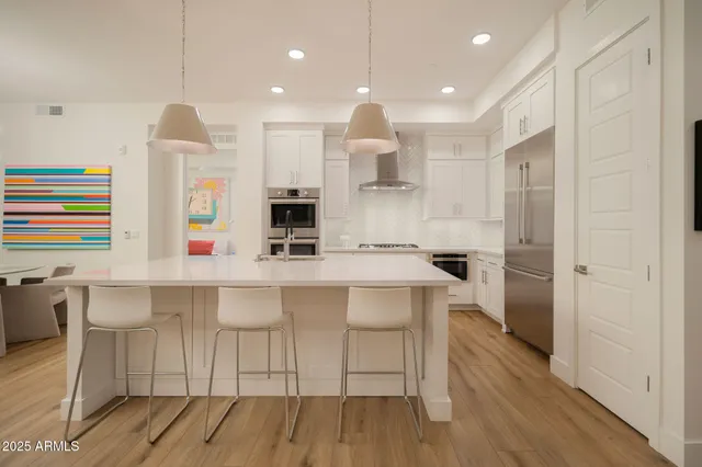 a kitchen with stainless steel appliances a sink and a refrigerator