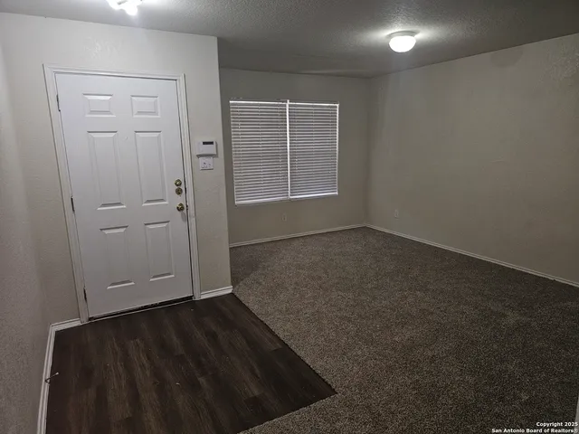 an empty room with wooden floor closet and windows