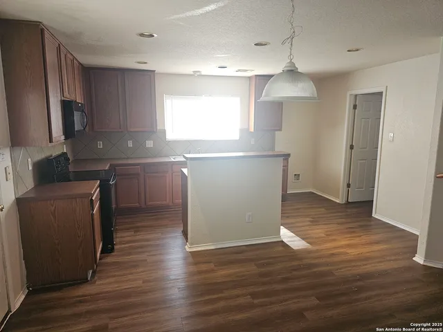 a kitchen with wooden floors and refrigerator