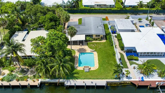 an aerial view of a house with a garden and lake view