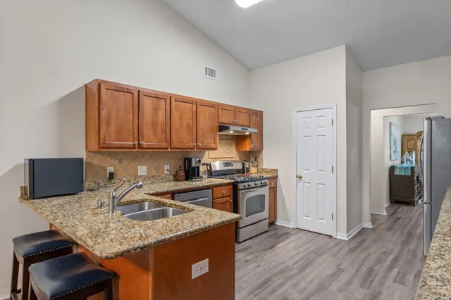 a kitchen with stainless steel appliances granite countertop a sink stove and refrigerator