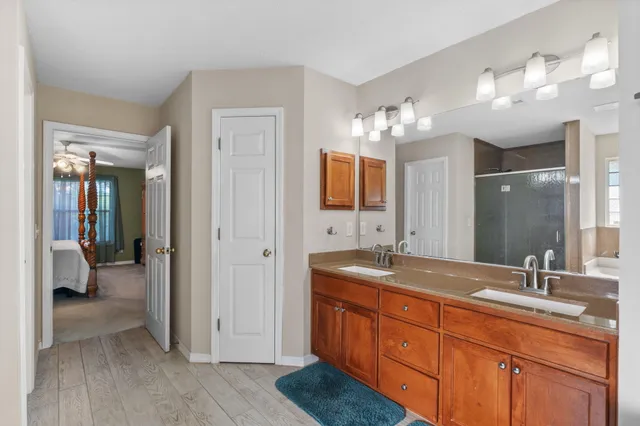 a spacious bathroom with a granite countertop sink mirror and shower