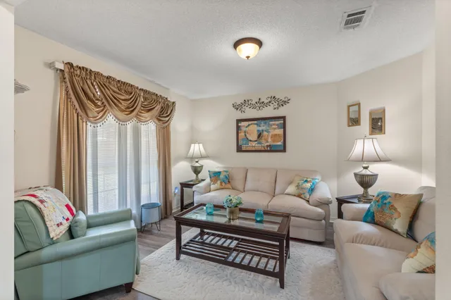 a living room with furniture a rug and a window