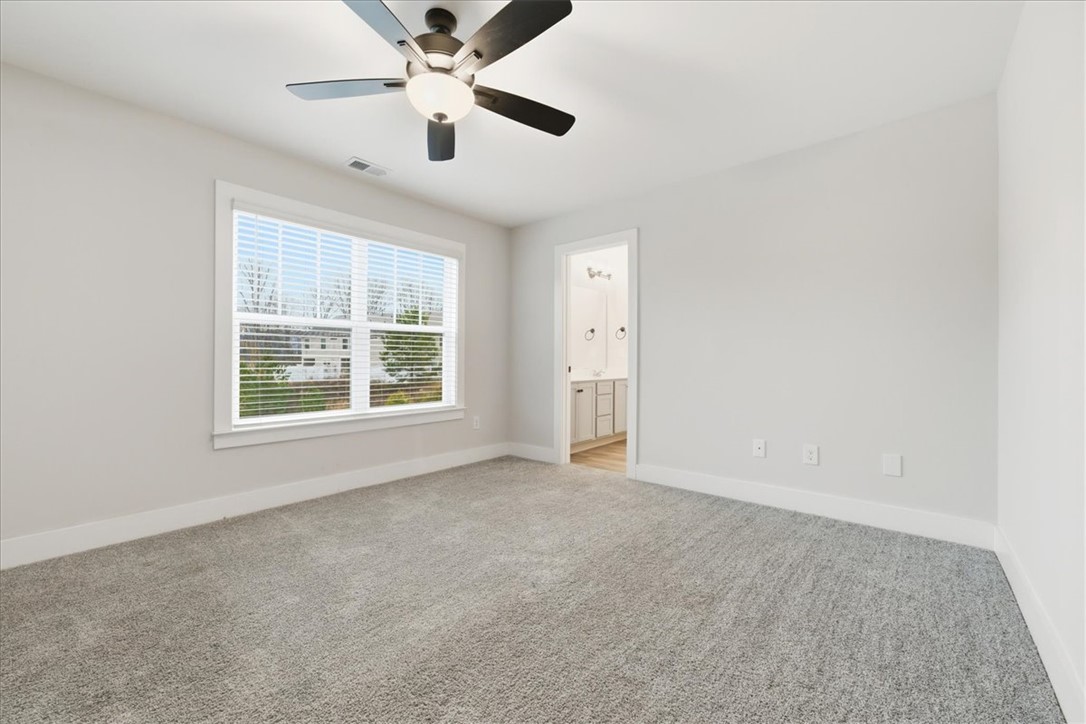 427 Bee Cv Way Pendleton, SC 29670 - Photo 28 of 32 A spacious bedroom provides a tranquil retreat, featuring plush carpet and a clear view through the window.