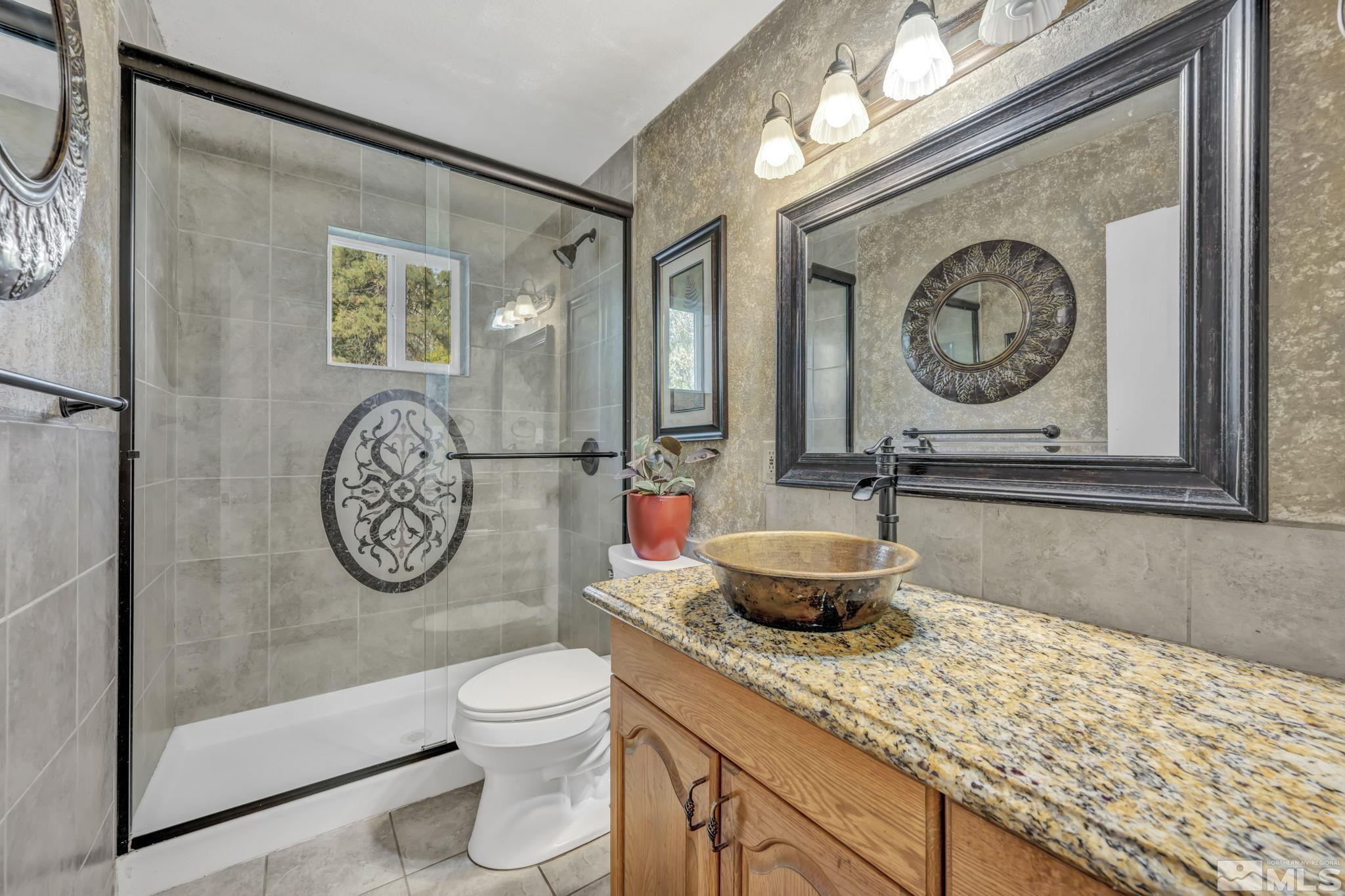55 Surrey Drive Reno, NV 89521 - Photo 21 of 40 a bathroom with a toilet a sink and a mirror