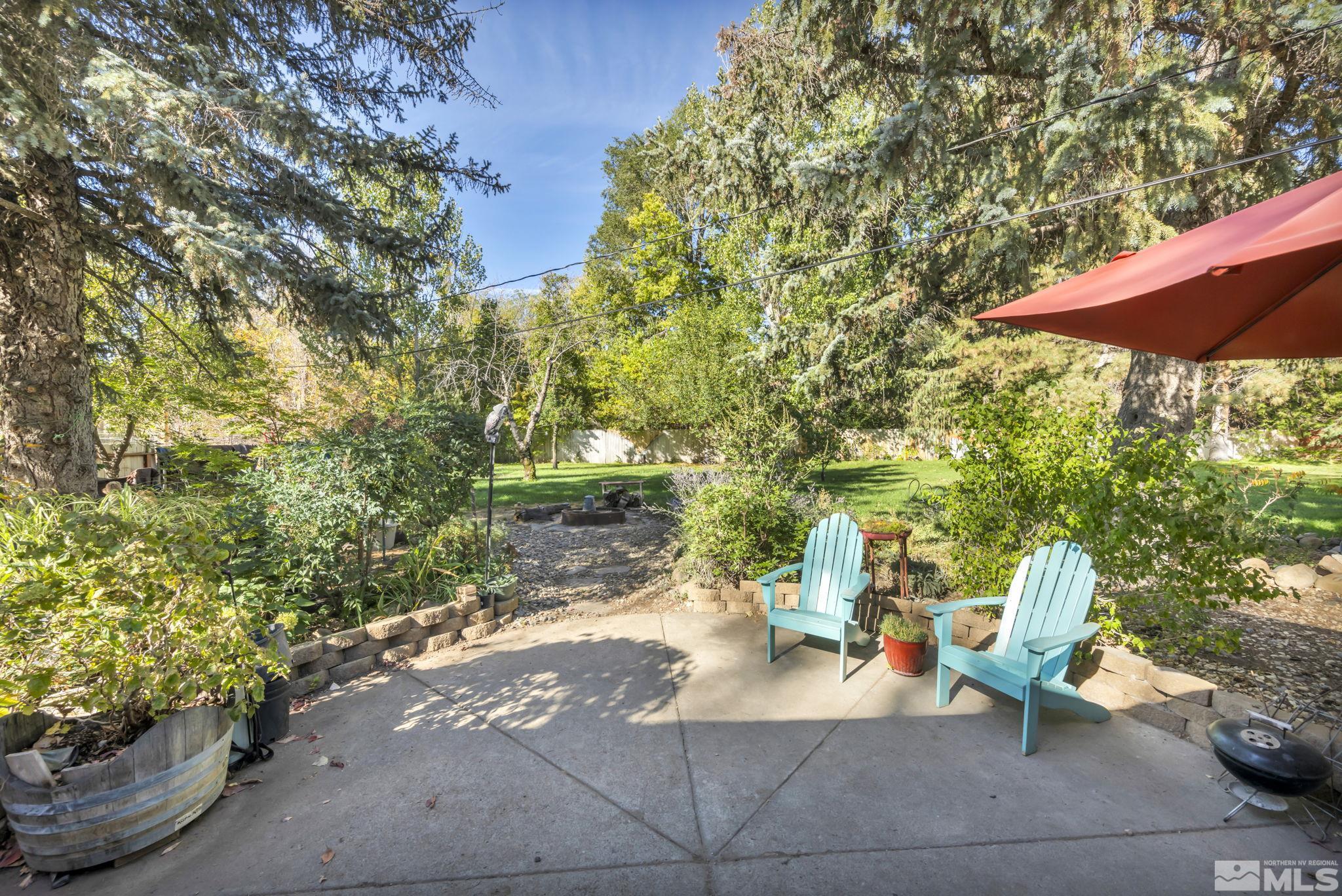 55 Surrey Drive Reno, NV 89521 - Photo 27 of 40 a view of a patio with table and chairs potted plants and large tree