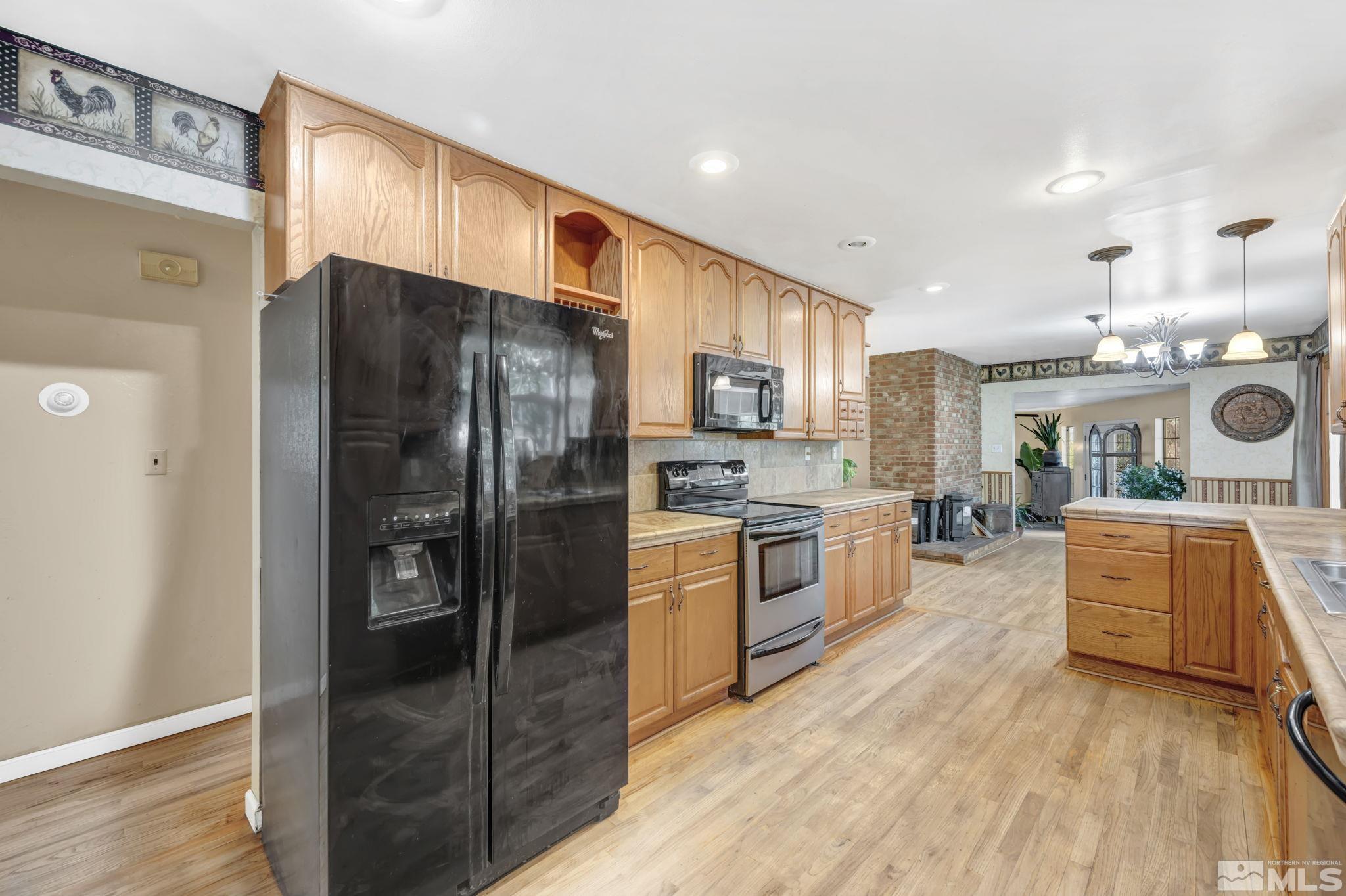55 Surrey Drive Reno, NV 89521 - Photo 6 of 40 a kitchen with stainless steel appliances a refrigerator sink and stove