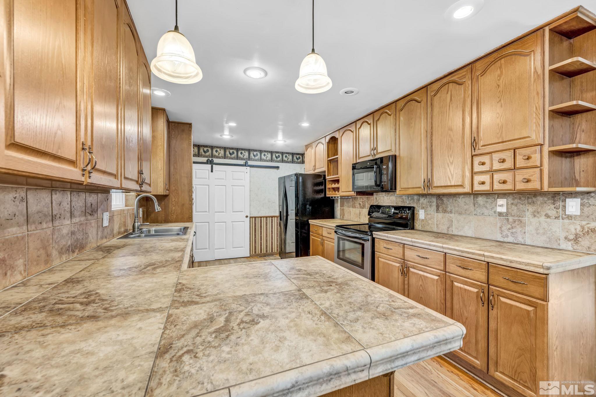 55 Surrey Drive Reno, NV 89521 - Photo 9 of 40 a kitchen with stainless steel appliances granite countertop a sink a stove cabinets and wooden floor