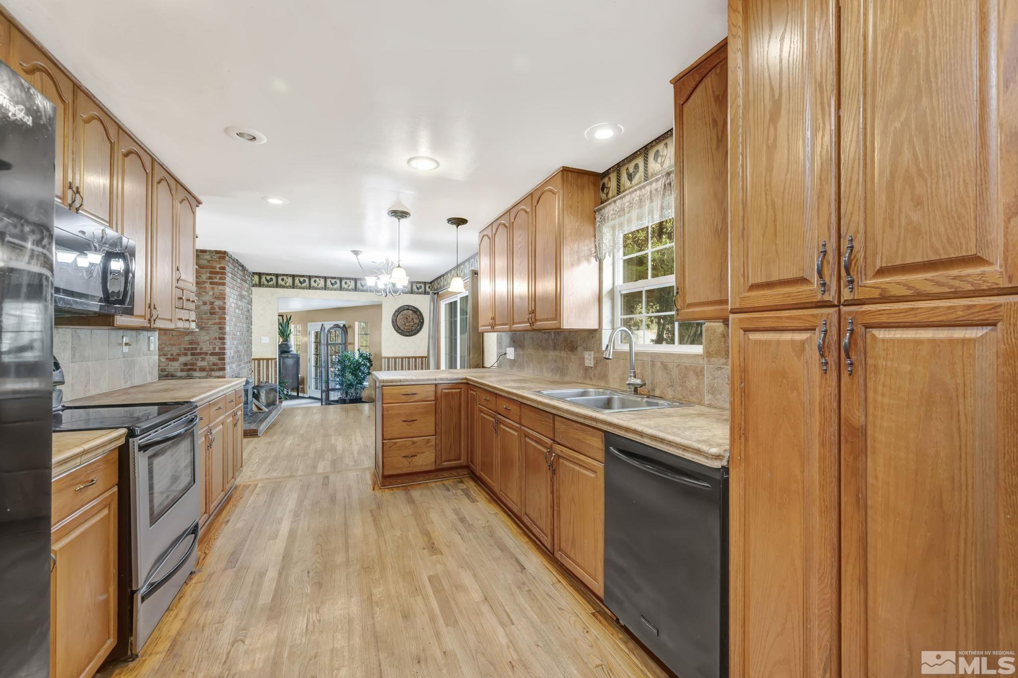 55 Surrey Drive Reno, NV 89521 - Photo 10 of 40 a large kitchen with stainless steel appliances granite countertop lots of counter top space and wooden floor