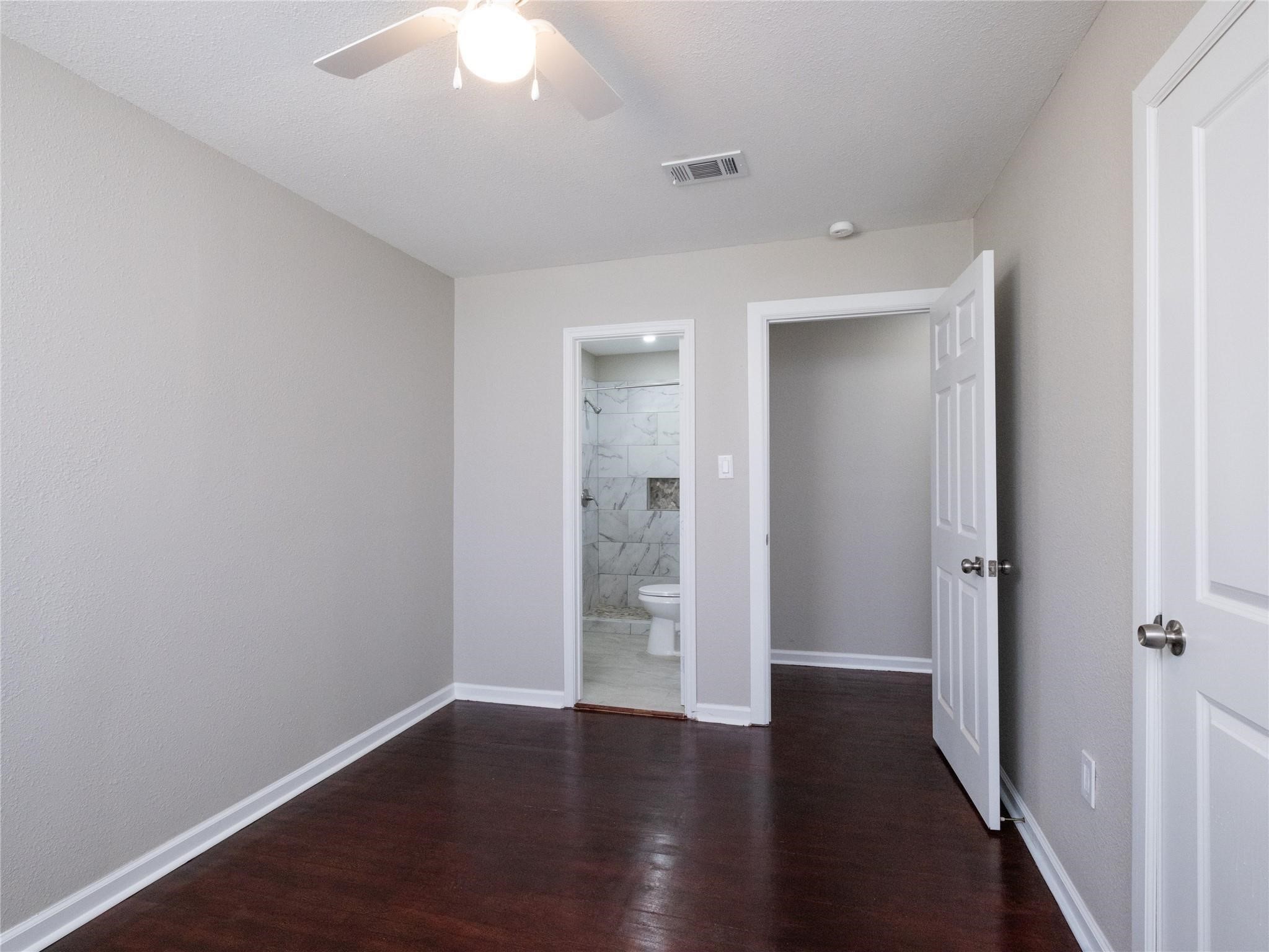 3215 Soway Street Houston, TX 77080 - Photo 13 of 29 an empty room with wooden floor and a ceiling fan