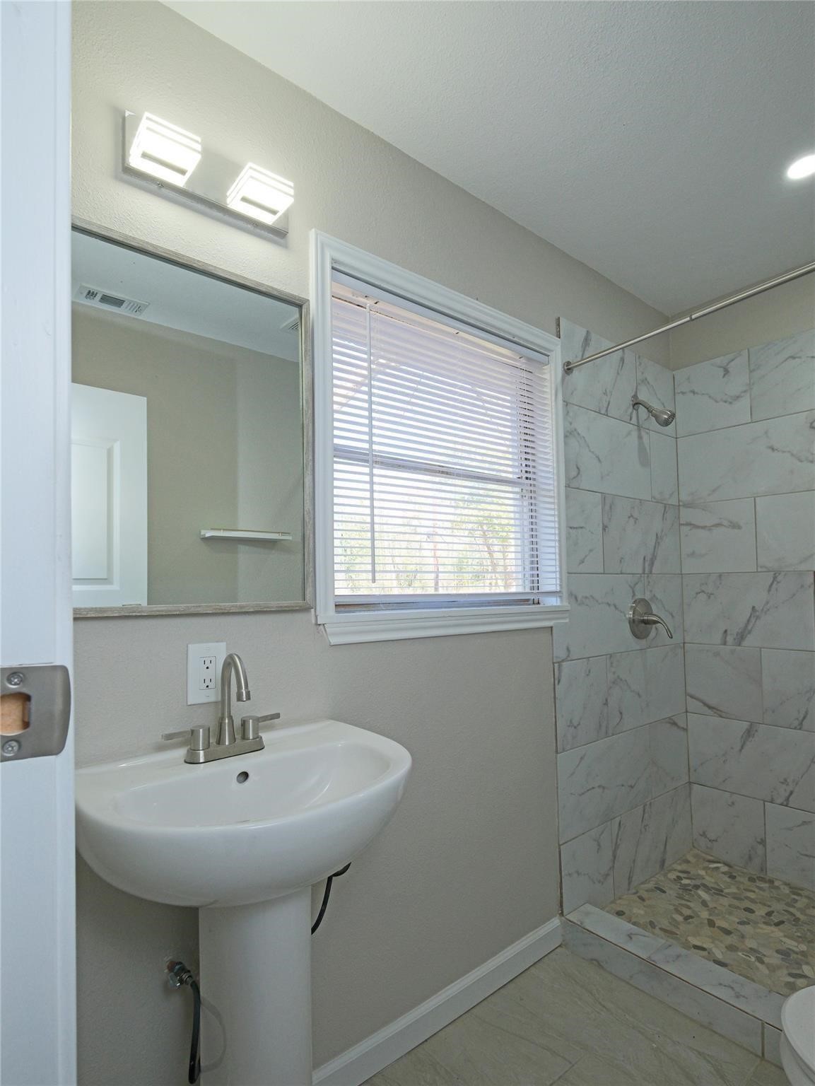 3215 Soway Street Houston, TX 77080 - Photo 14 of 29 a bathroom with a sink a shower and a mirror
