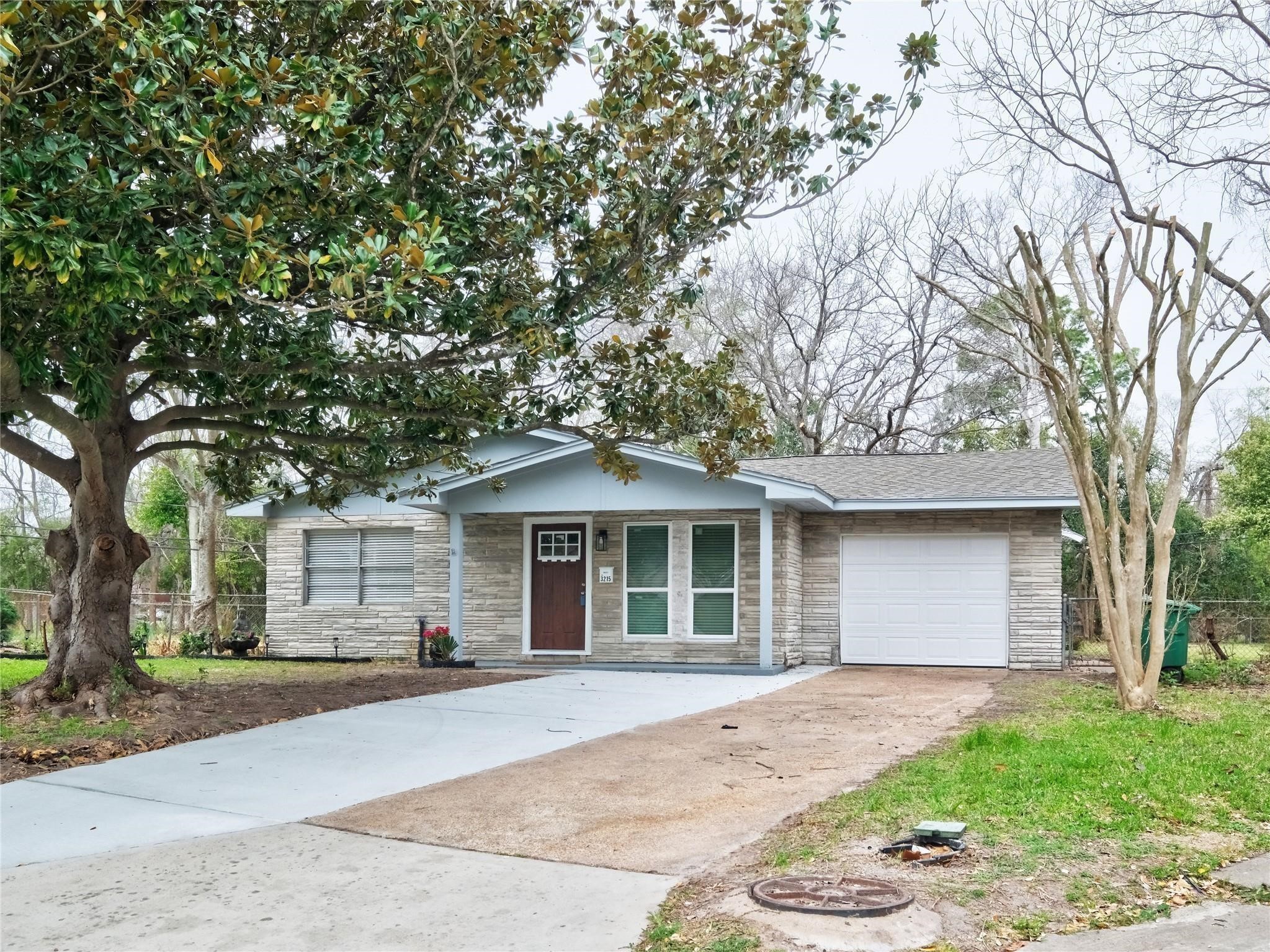 3215 Soway Street Houston, TX 77080 - Photo 28 of 29 a front view of a house with a garden and trees