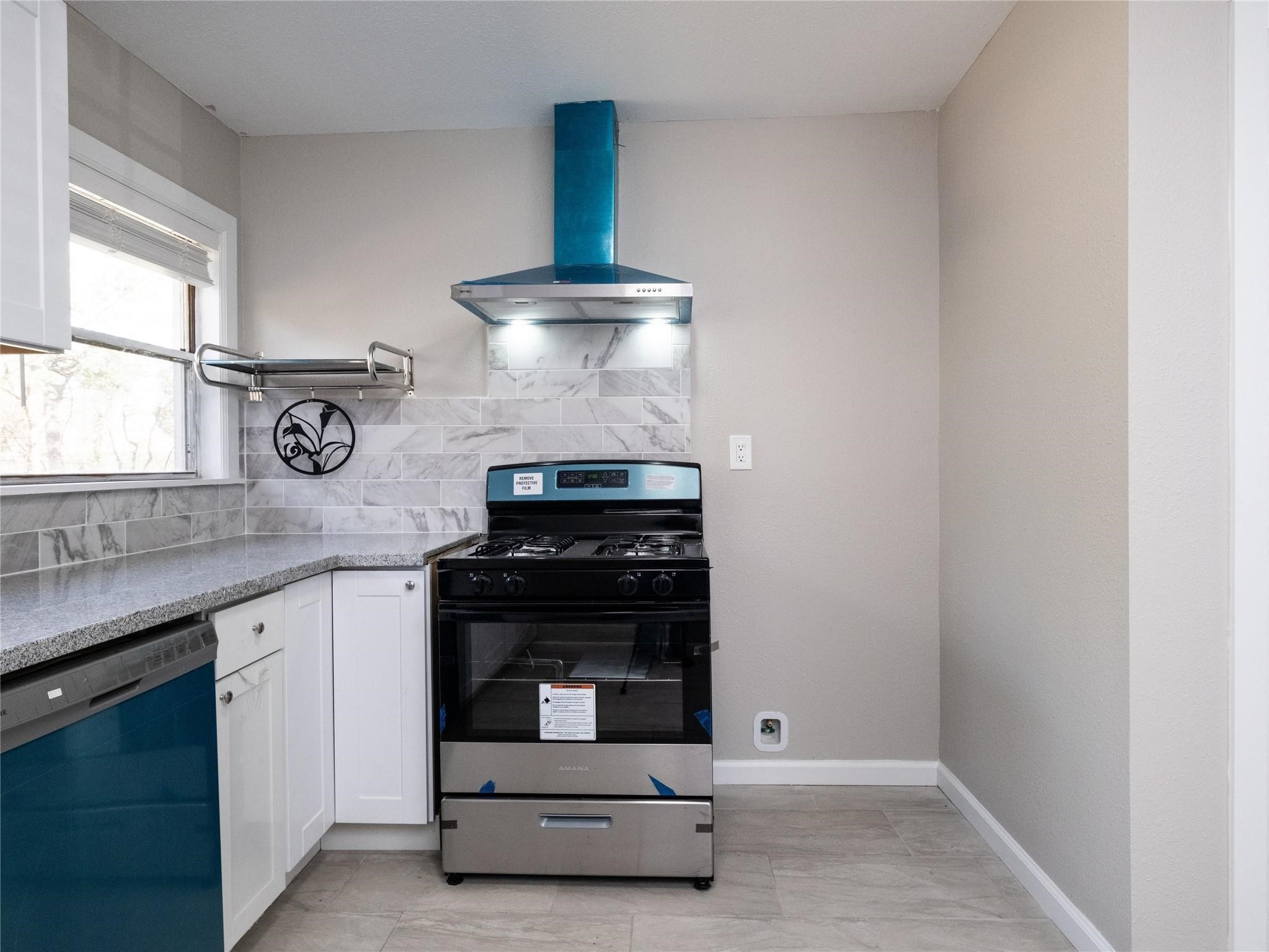 3215 Soway Street Houston, TX 77080 - Photo 4 of 29 a kitchen with a stove and white cabinets