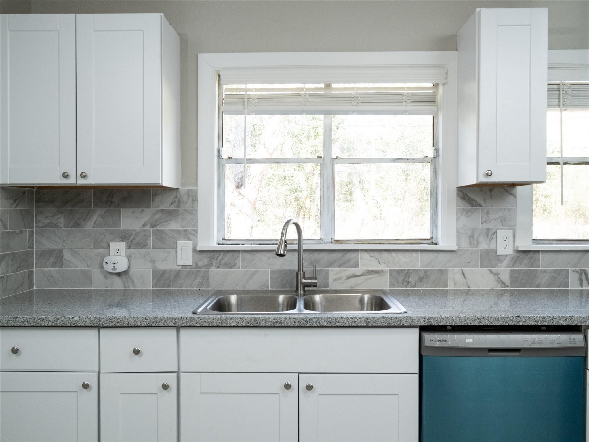 3215 Soway Street Houston, TX 77080 - Photo 5 of 29 a kitchen with stainless steel appliances granite countertop white cabinets and a window