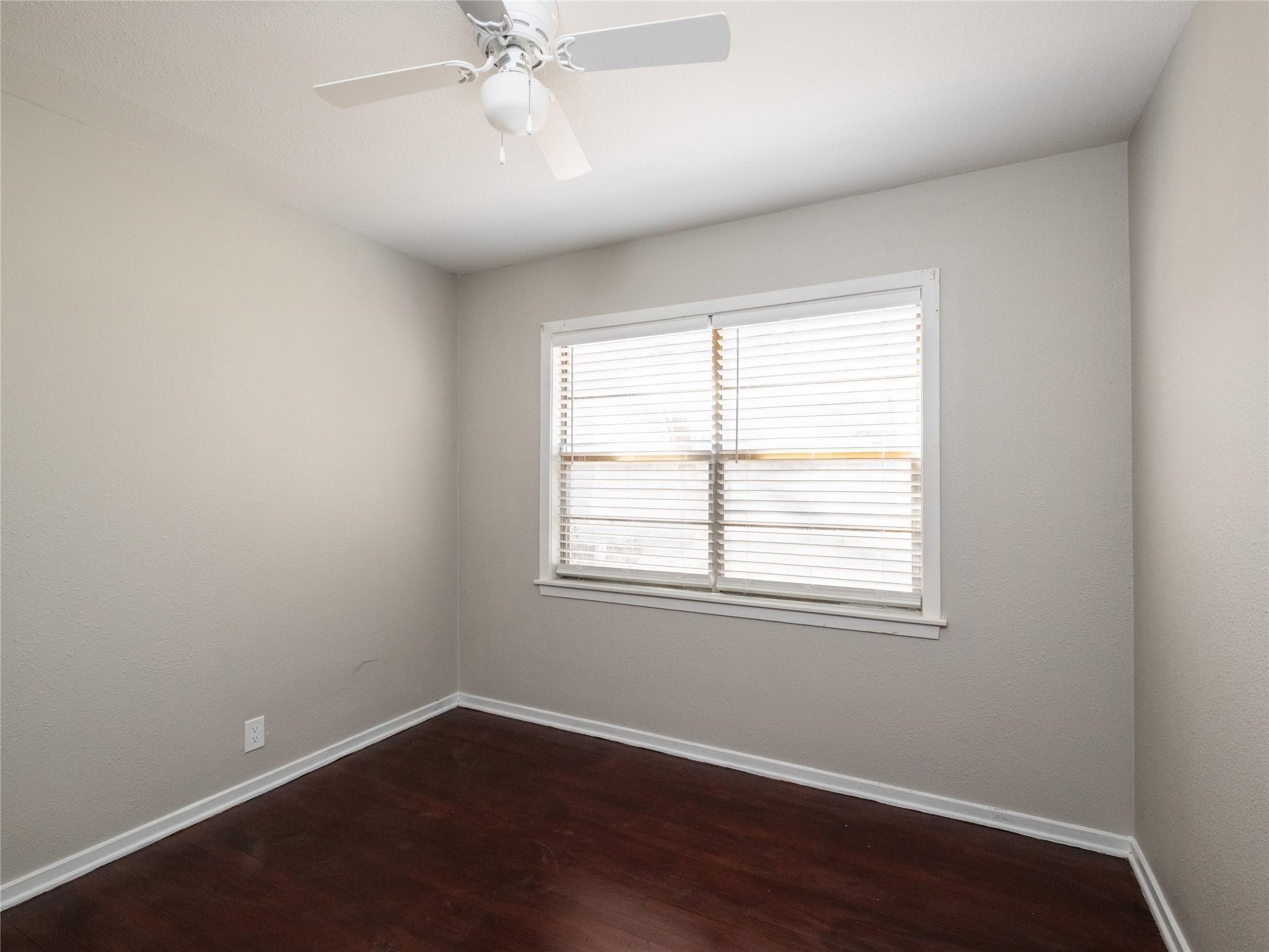 3215 Soway Street Houston, TX 77080 - Photo 8 of 29 an empty room with wooden floor windows and fan