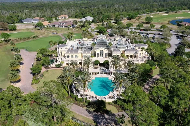 a view of a white house with a big yard and potted plants