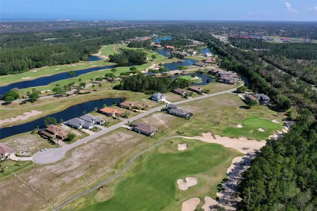 a view of a golf ground with huge green field and trees in the background