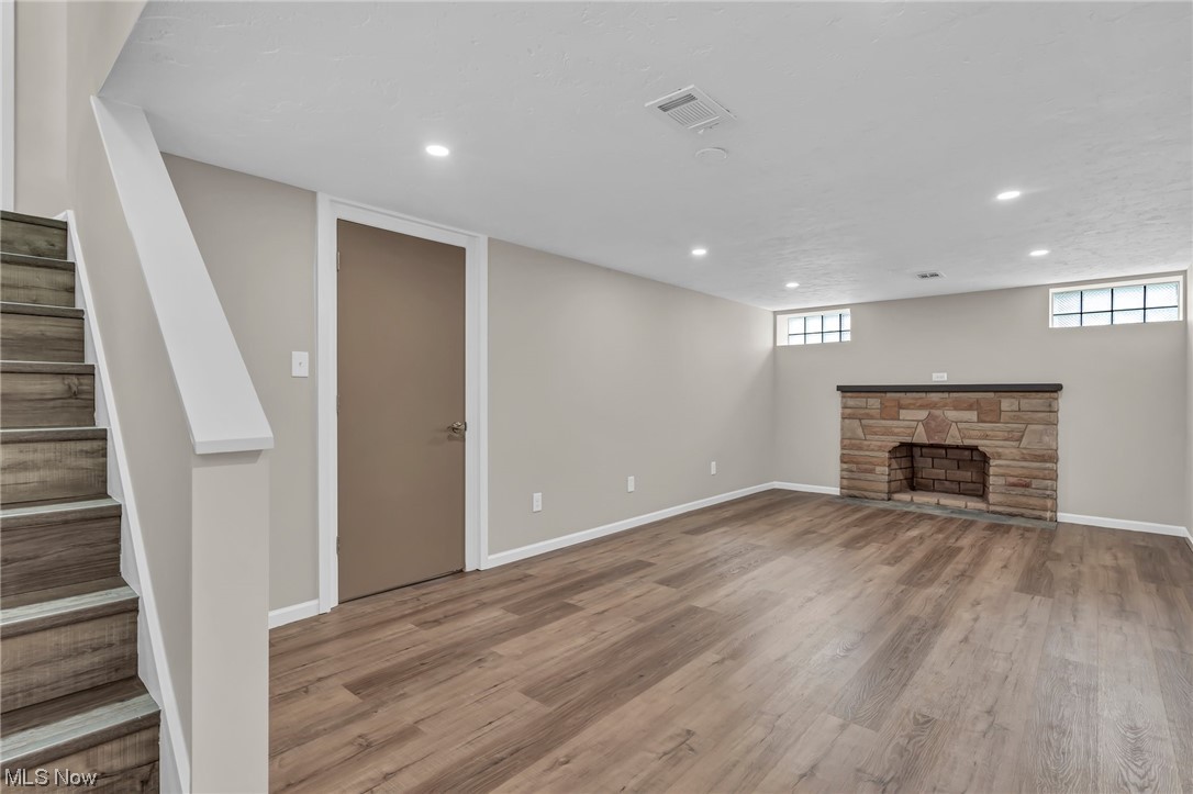 3669 Silsby Road University Heights, OH 44118 - Photo 33 of 34 Rec room with new walls, LVT flooring, recessed lighting, & wood-burning fireplace hearth