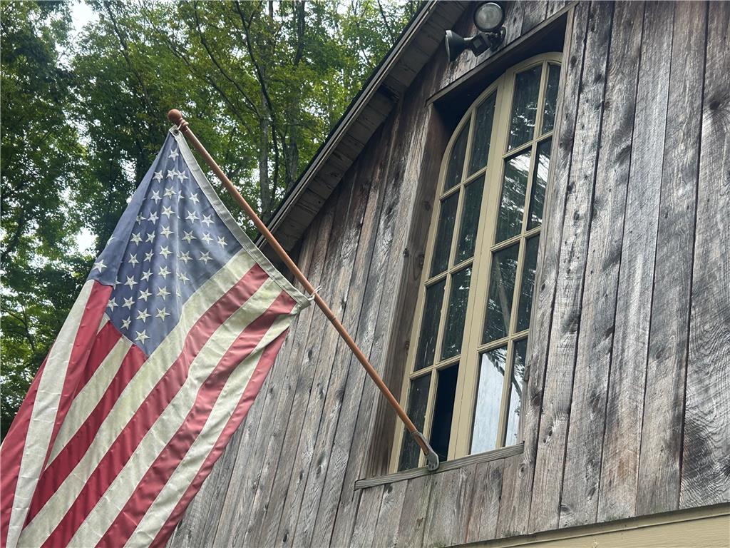 7 Allegheny Road Mount Bethel, PA 18343 - Photo 11 of 71 Weathered wood siding surrounds a prominent arched multi-lite window on the rustic exterior.