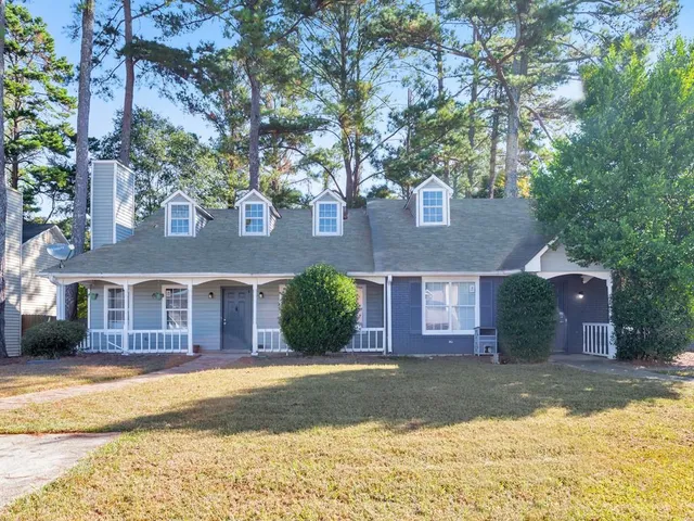 a front view of a house with a yard and trees
