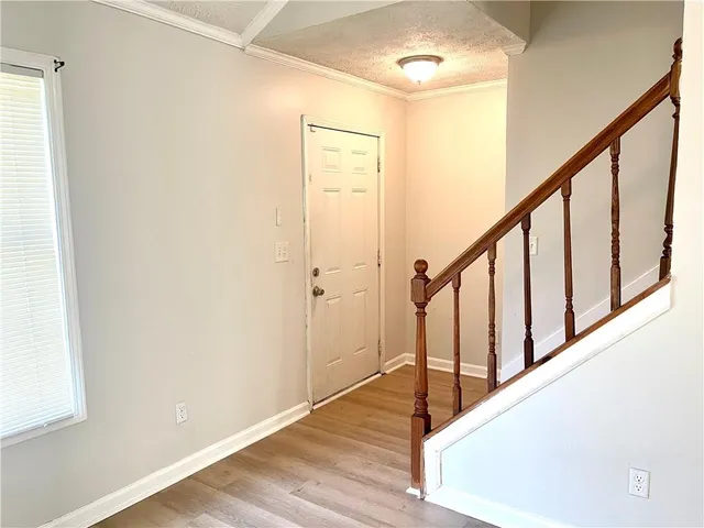 a view of staircase with wooden floor and white walls