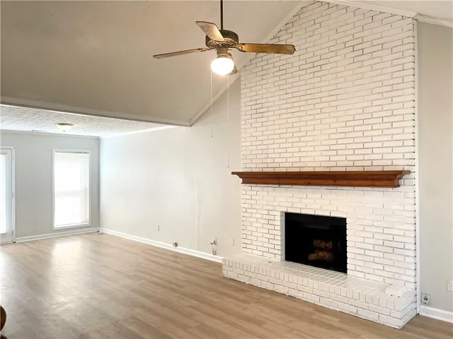 an empty room with wooden floor a fireplace