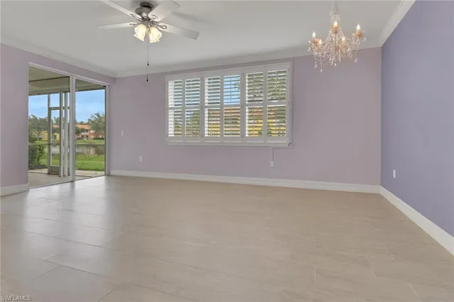 a view of an empty room with chandelier fan and fire place