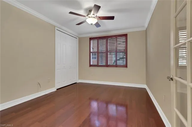 a view of an empty room with a window and wooden floor