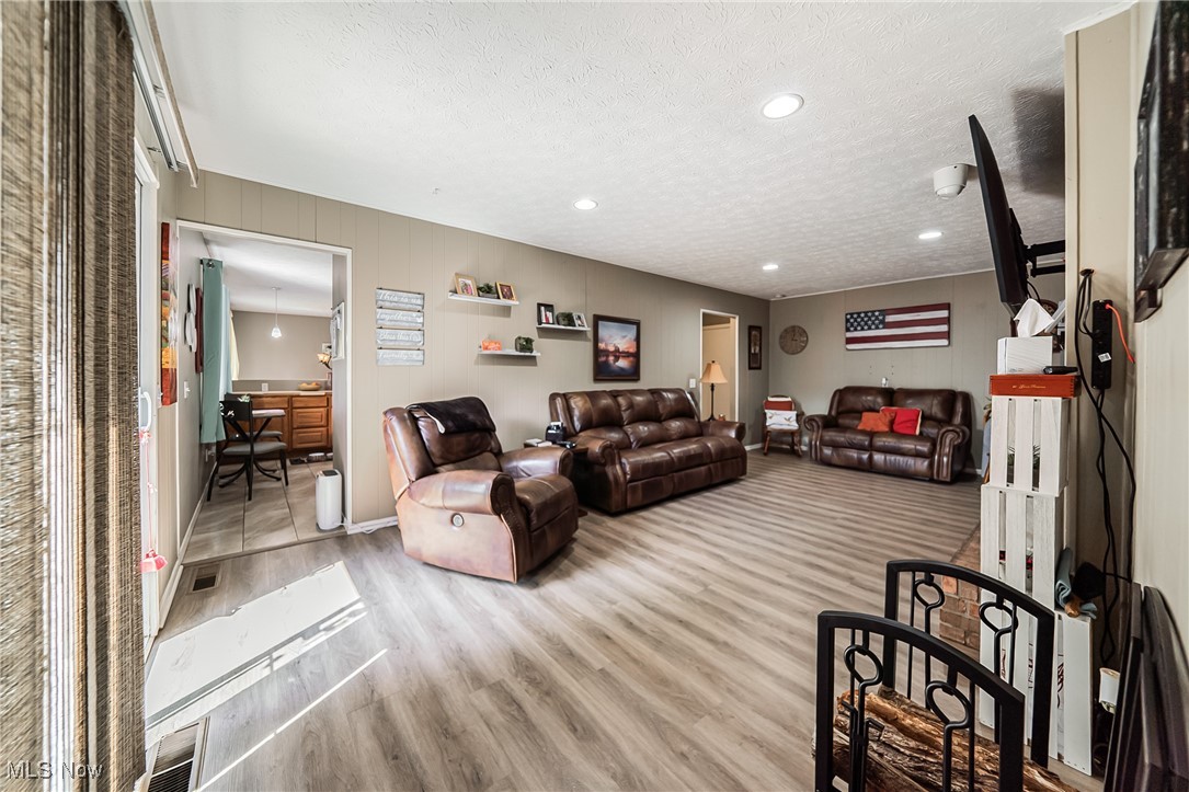 10794 Waterfall Road Strongsville, OH 44149 - Photo 14 of 37 Living room featuring a textured ceiling, light wood-style floors, recessed lighting, and an office area
