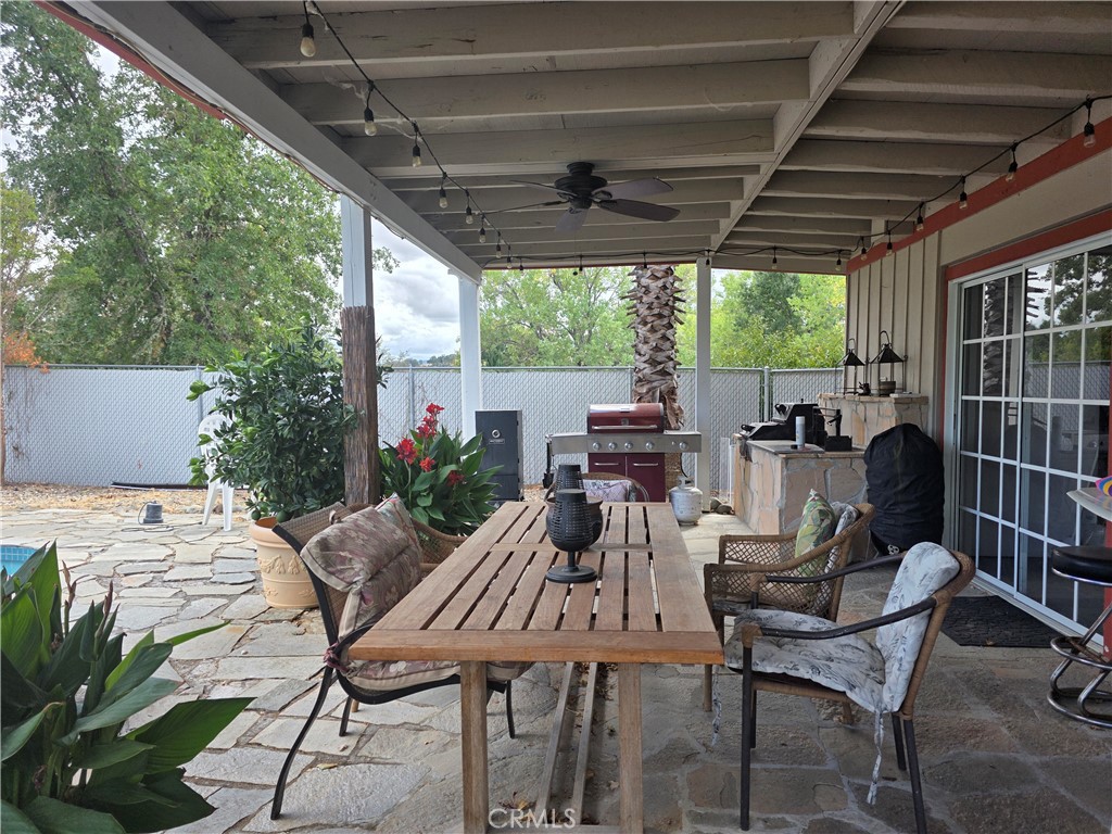 4504 Eickhoff Road Lakeport, CA 95453 - Photo 28 of 40 a view of a patio with table and chairs a barbeque with wooden floor and roof with potted plants