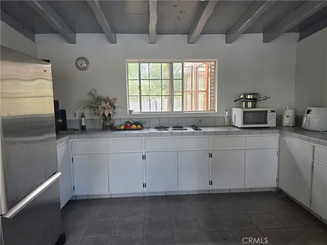 a view of a patio with table and chairs potted plants with wooden floor and fence