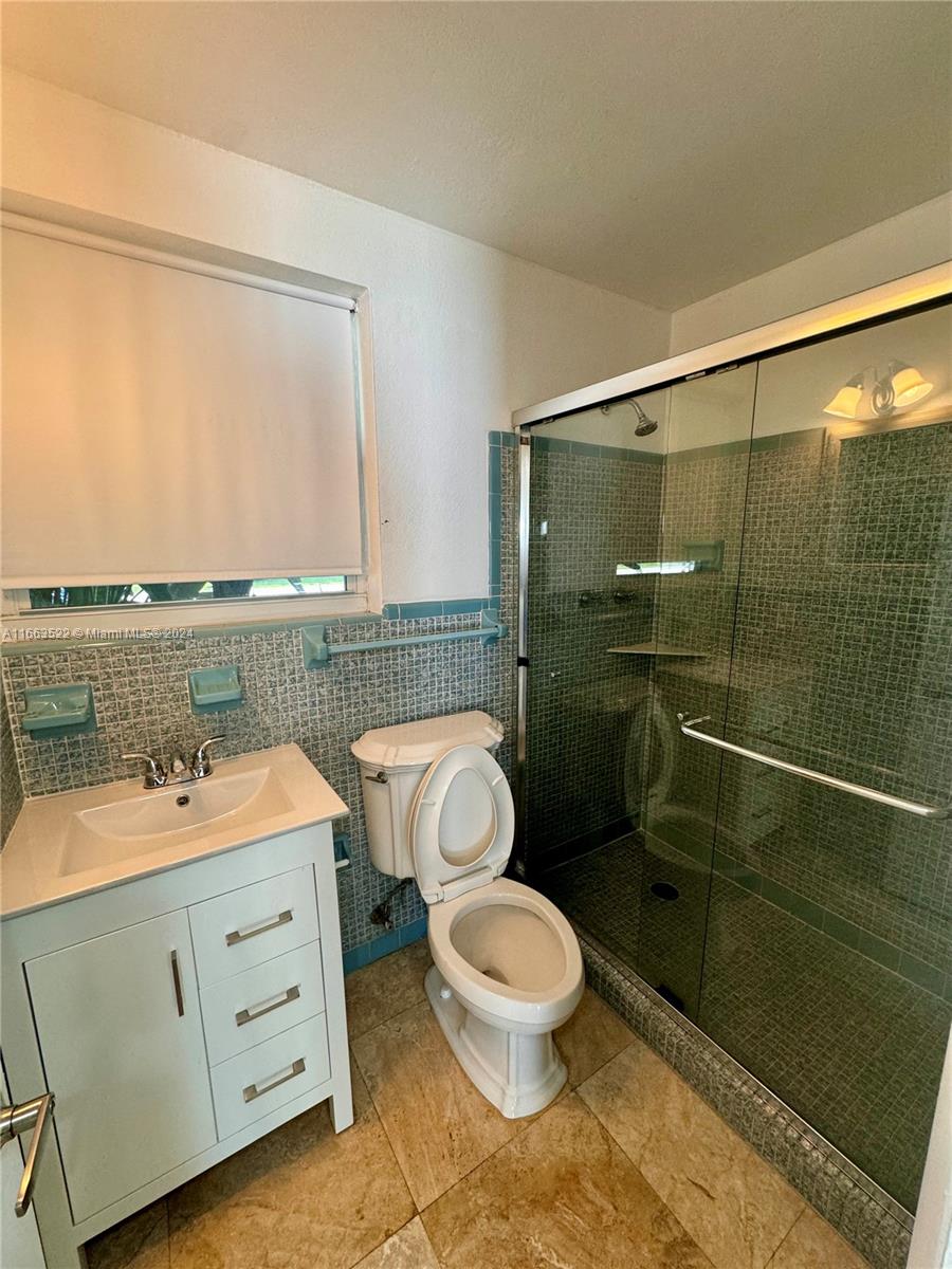 8945 Southwest 125th Terrace, Unit 8945 Miami, FL 33176 - Photo 19 of 29 a bathroom with a double vanity sink toilet and shower