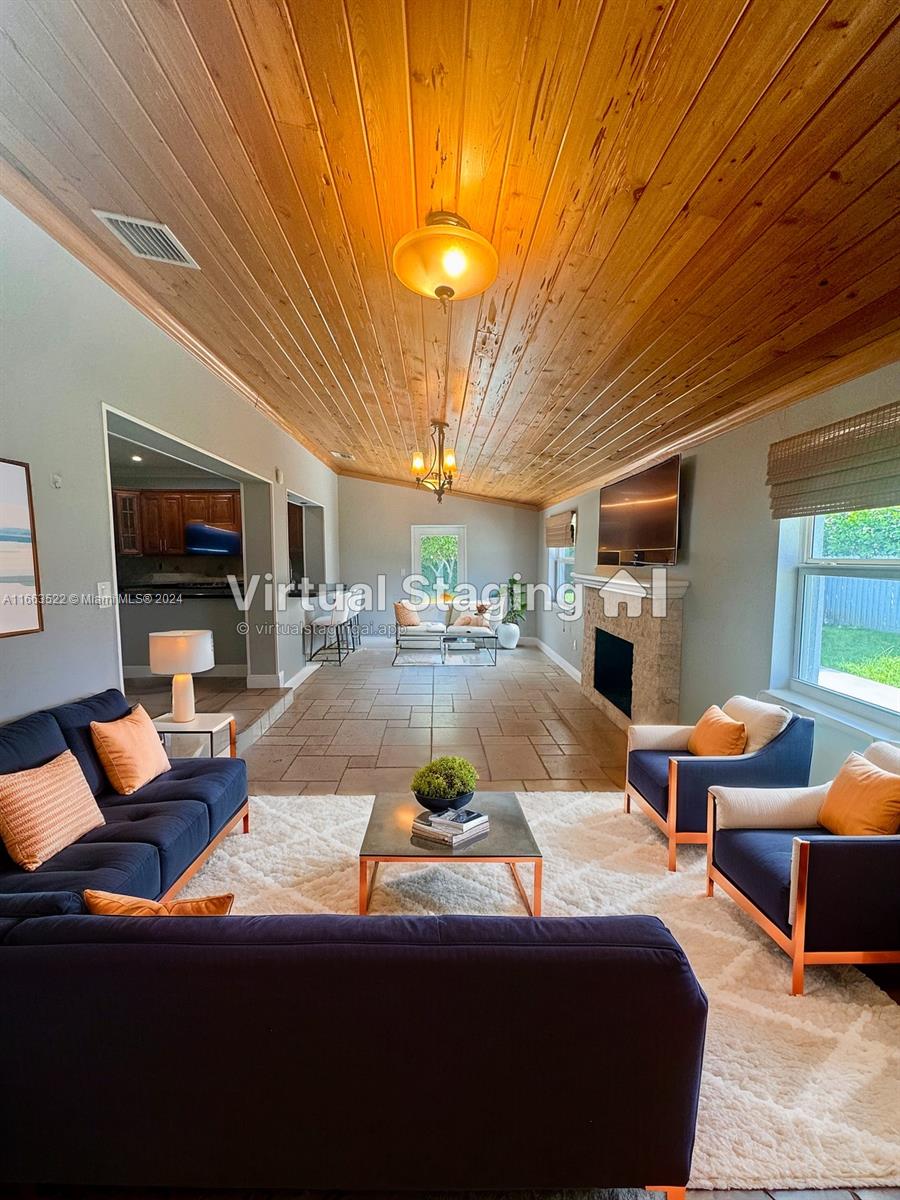 8945 Southwest 125th Terrace, Unit 8945 Miami, FL 33176 - Photo 29 of 29 a living room with furniture a flat screen tv and kitchen view