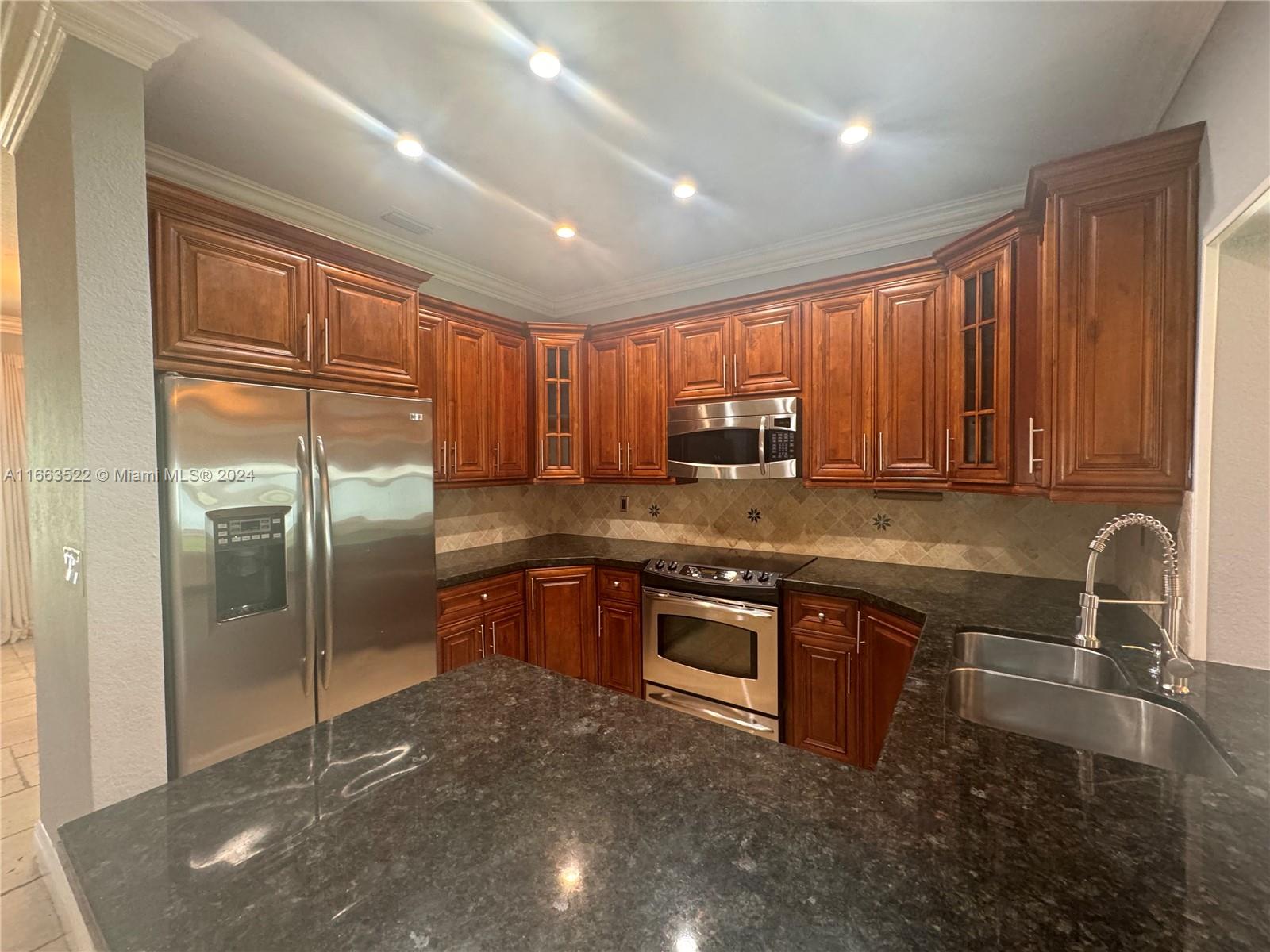 8945 Southwest 125th Terrace, Unit 8945 Miami, FL 33176 - Photo 6 of 29 a kitchen with stainless steel appliances granite countertop a stove a sink and a microwave