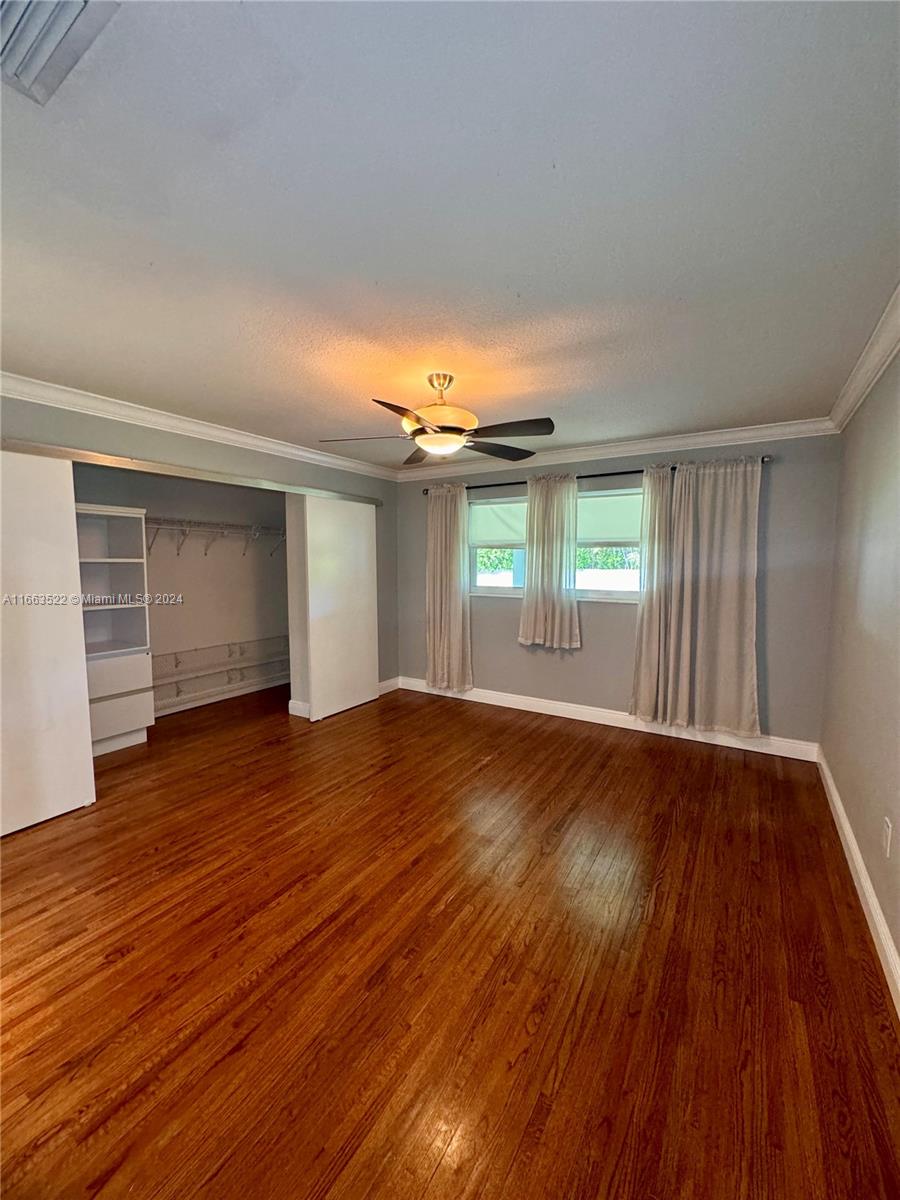 8945 Southwest 125th Terrace, Unit 8945 Miami, FL 33176 - Photo 9 of 29 an empty room with wooden floor and windows