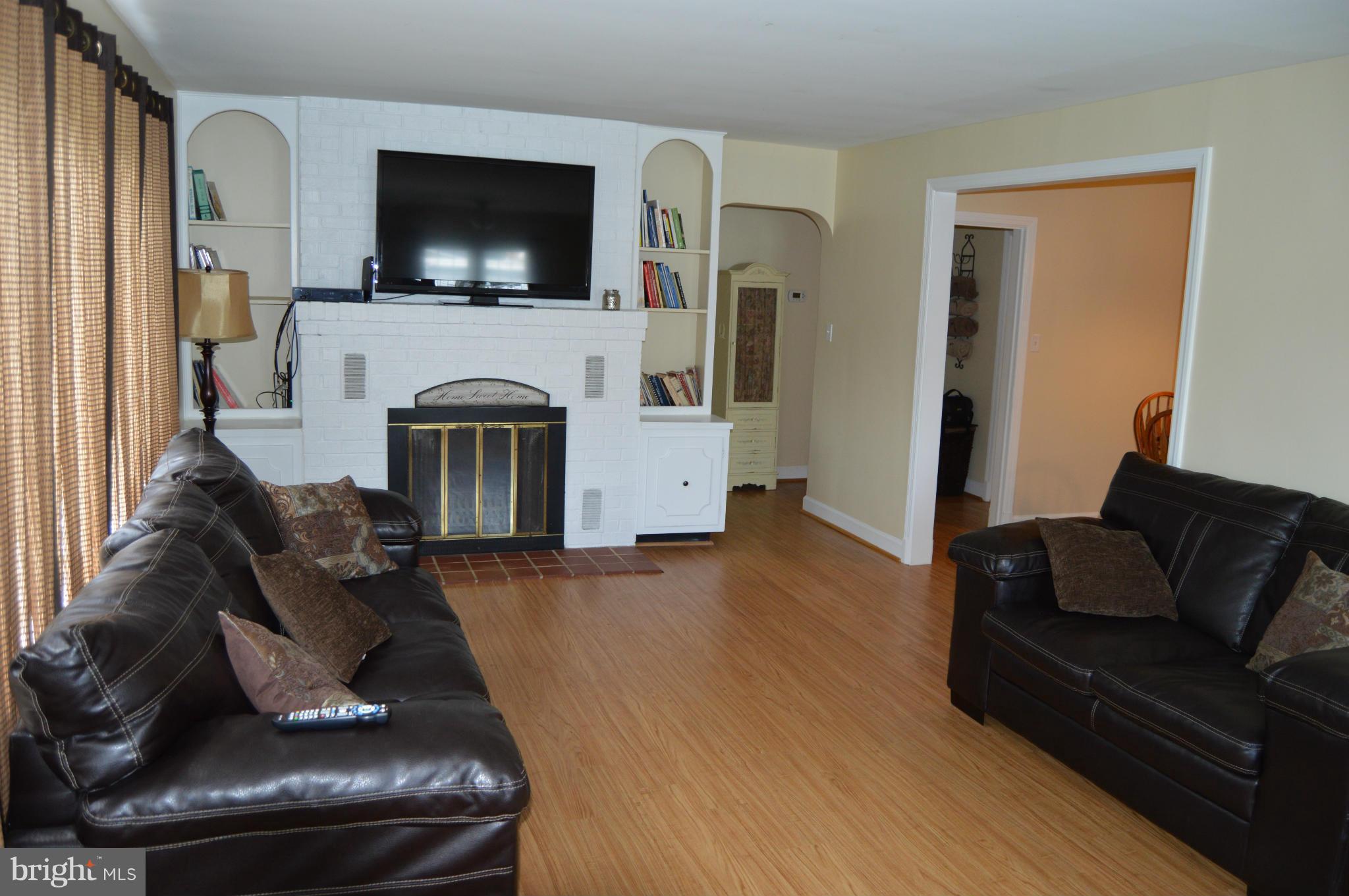 8471 Church Road Pasadena, MD 21122 - Photo 2 of 18 a living room with furniture a flat screen tv and a fireplace