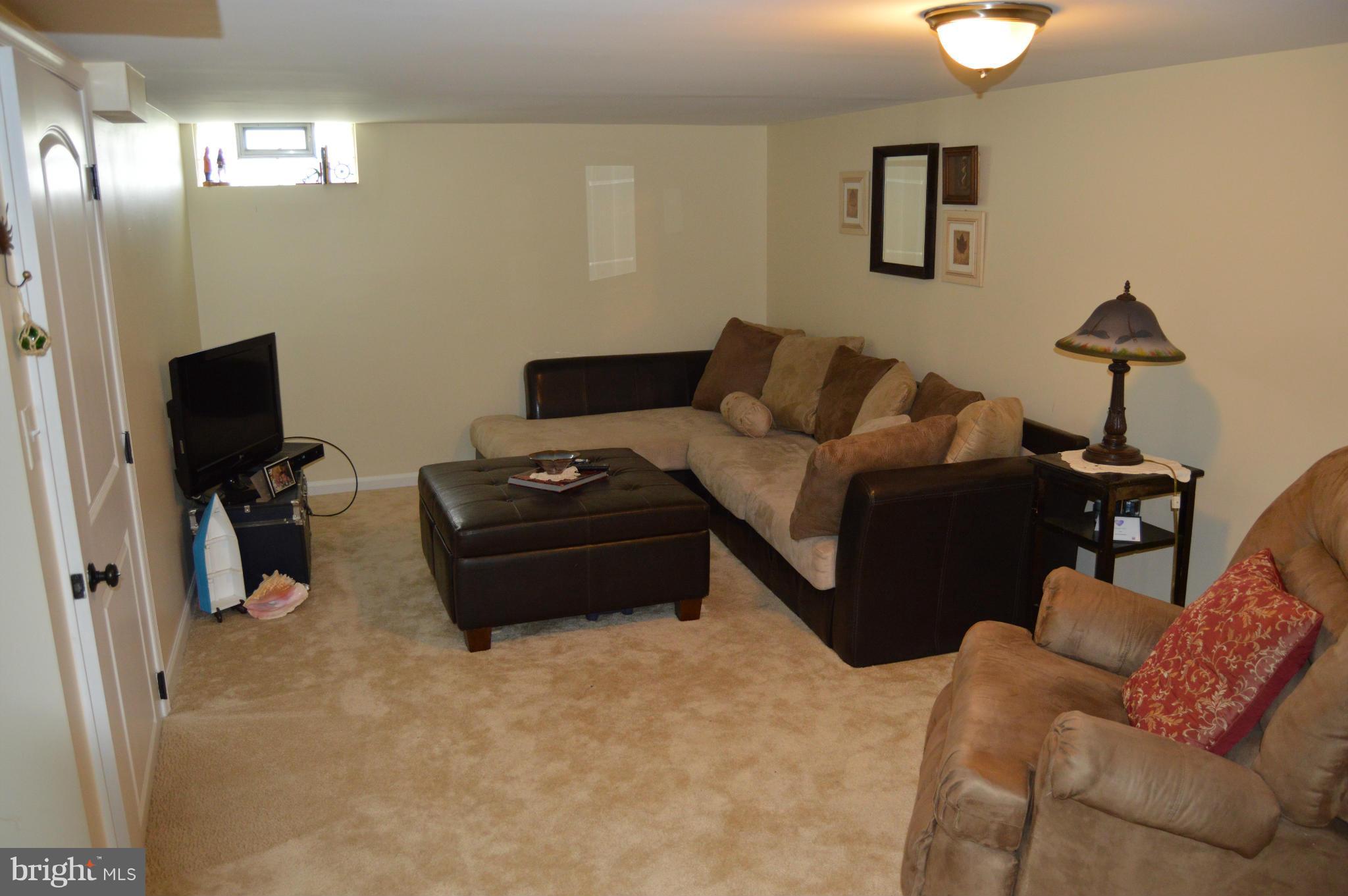 8471 Church Road Pasadena, MD 21122 - Photo 11 of 18 a living room with furniture a flat screen tv and a lamp